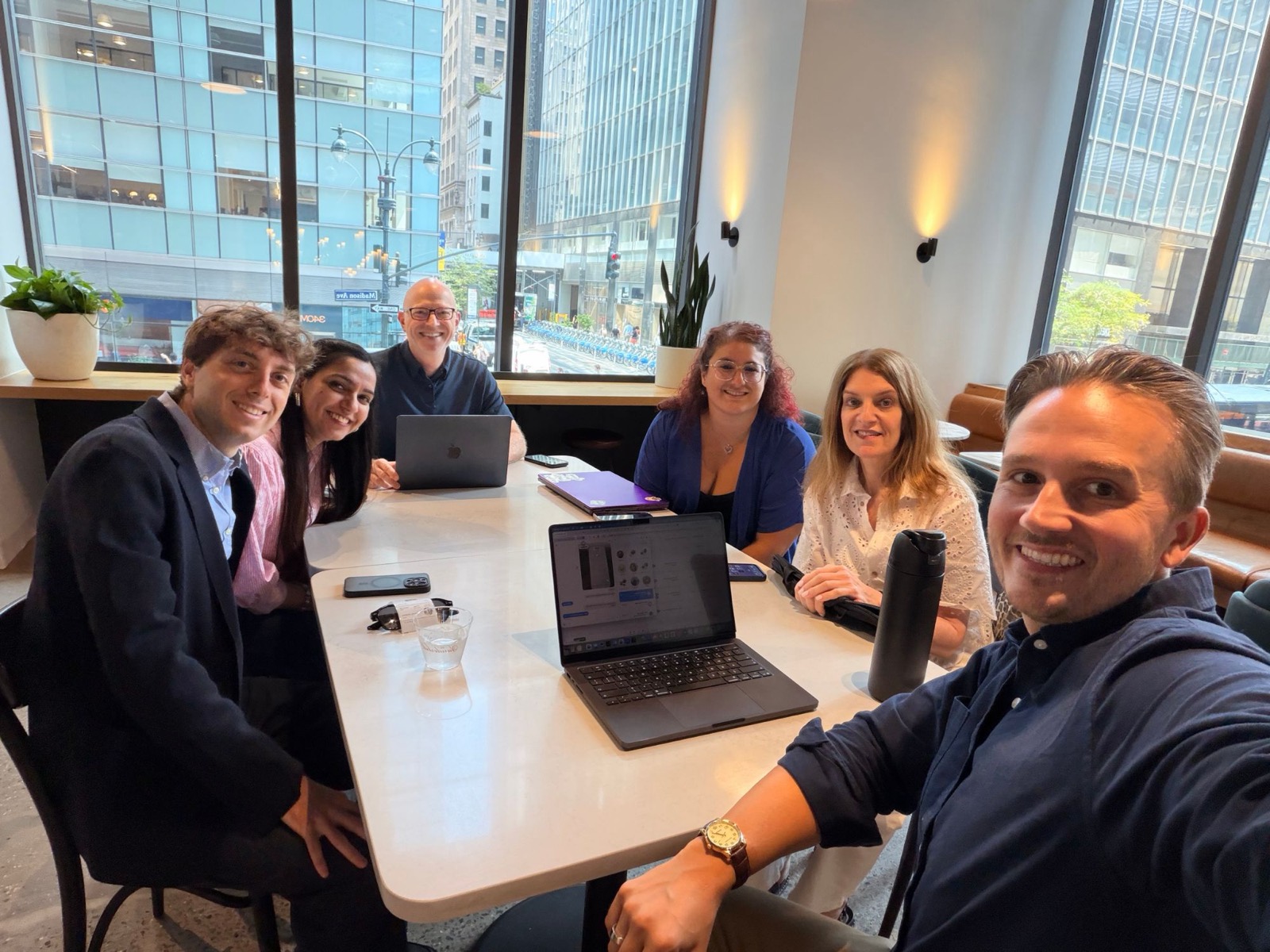 Part of the Demure team working together around a table